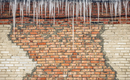 Background - old shabby brick wall with iciclesの写真素材