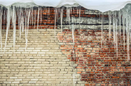 Background - old shabby brick wall with iciclesの写真素材