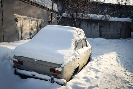 Snowdrift on an abandoned old car in industrial zone. Winter. Season specific. Outdoorsの写真素材
