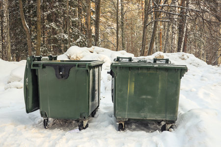 Two green garbage cans in with snow on top in winter. Outdoorsの写真素材
