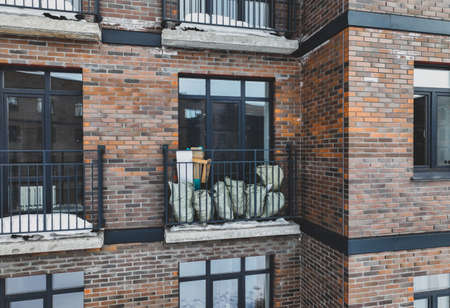 Bags with construction debris on a small balcony close-up. brick house