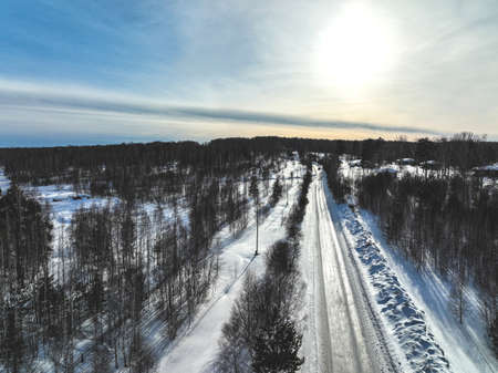 Road in the winter forest. aerial view. Sunsetの写真素材