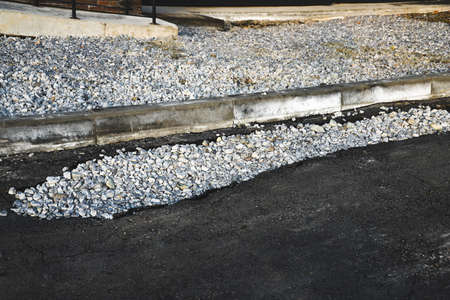 Pit filled with rubble on road close-up. Defect fix on asphaltの写真素材