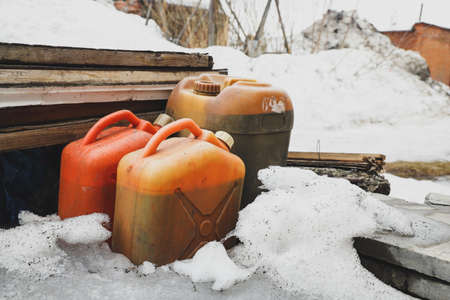 Old plastic canisters in the snow. industrial backgroundの写真素材