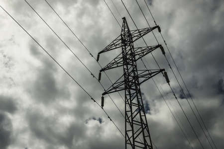 Power line pylon against the background of the dark cloudy sky