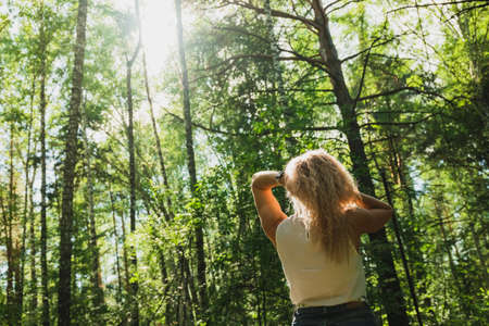 The young woman walks in a forest on a sunny dayの写真素材