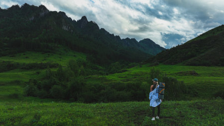 The girl admires the beautiful view of the mountains in summer time. travel conceptの写真素材