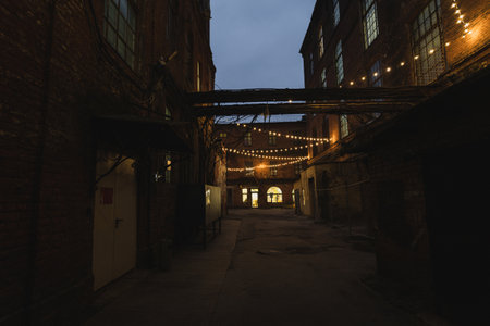 Dark street in an industrial area illuminated by small lanternsの写真素材