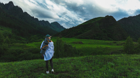 The girl admires the beautiful view of the mountains in summer time. travel conceptの写真素材