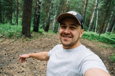 Man smiling and taking a selfie in the forestの写真素材