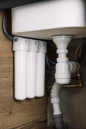 Home water filtration plant close-up. Small water filters under the sink in the kitchenの写真素材