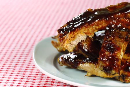 Barbecue cut up spare ribs on a checkered tableclothの写真素材
