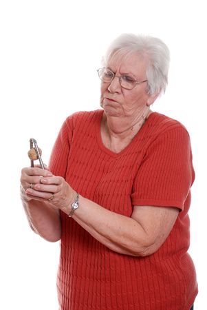 Senior woman struggling to crack a walnutの写真素材