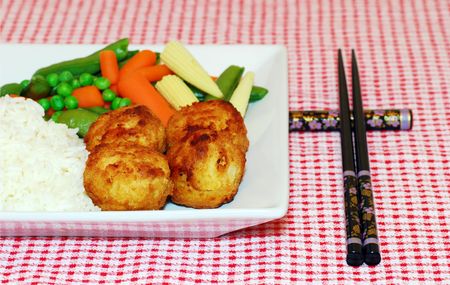 Chicken Balls with rice and mixed oriental vegetables and chop sticksの写真素材