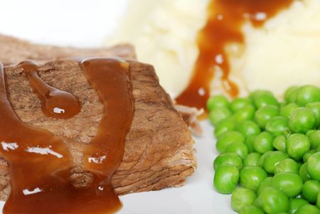 Closeup roast beef with gravy and vegetablesの写真素材