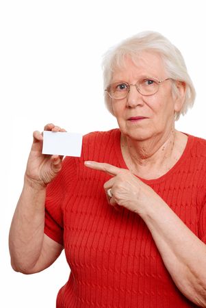  Isolated elderly woman pointing to a business card on a white backgroundの写真素材