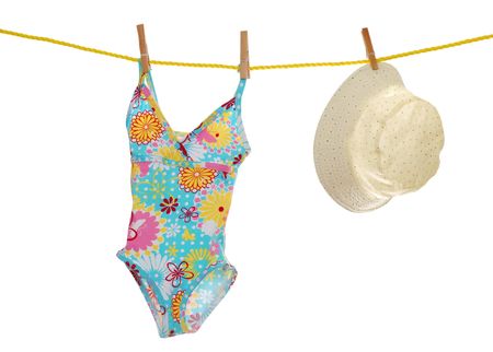 child's bathing suit and beach hat on clothes lineの写真素材