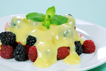 mixed berries with custard and mint on topの写真素材