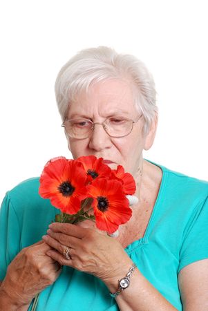   Senior woman with artificial red poppiesの写真素材