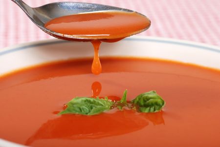 tomato soup dripping off a spoonの写真素材