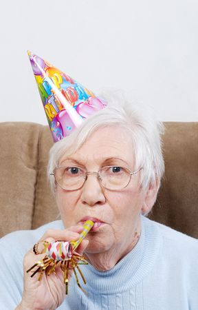 senior woman with birthday hat and noise maker