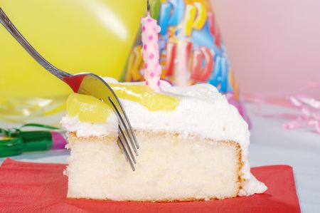macro fork cutting birthday cake with candleの写真素材