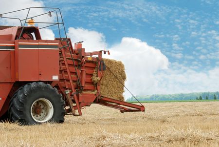 hay baler in the fieldの写真素材