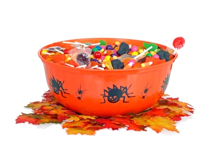 halloween candy in a bowl with fall leavesの写真素材
