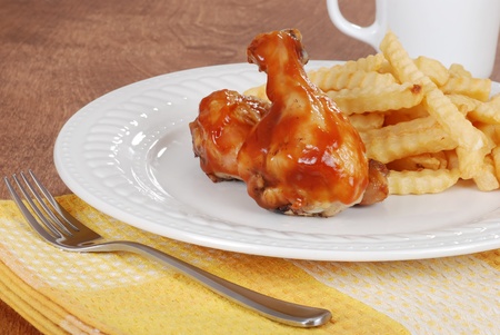 Chicken legs and french fries with barbecue sauceの写真素材