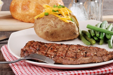 Barbecue steak with baked potato and cheeseの写真素材