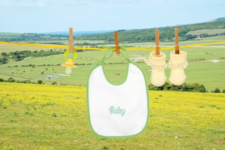 Baby bib socks and pacifier on clothes lineの写真素材