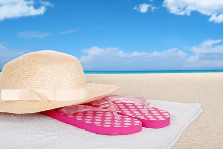 straw hat sandals on a beach towelの写真素材