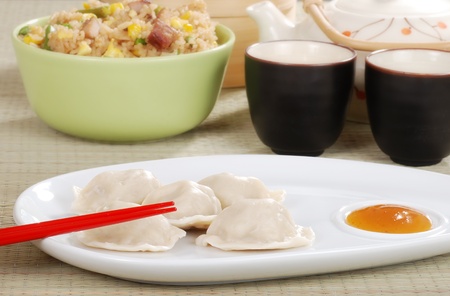 dumpling with plum sauce and chopsticksの写真素材