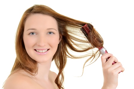 Young teen girl curling her hairの写真素材