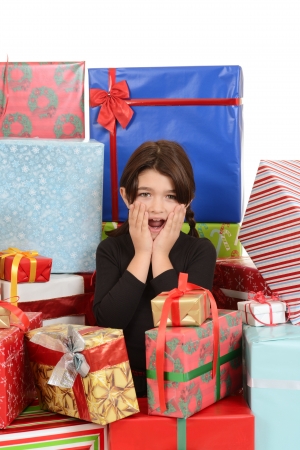Child surprised with lots of christmas giftsの写真素材