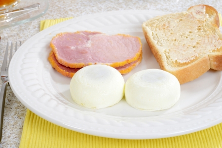 closeup of poached eggs with baconの写真素材