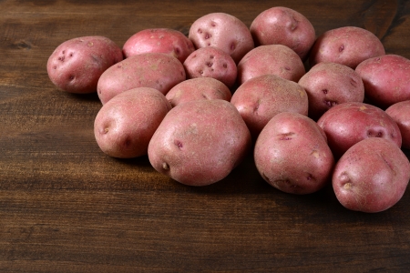 New red potatoes on woodの写真素材