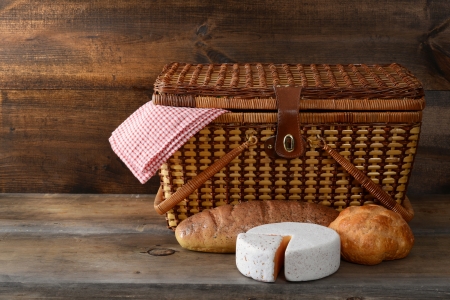 picnic basket with bread and cheese on woodの写真素材