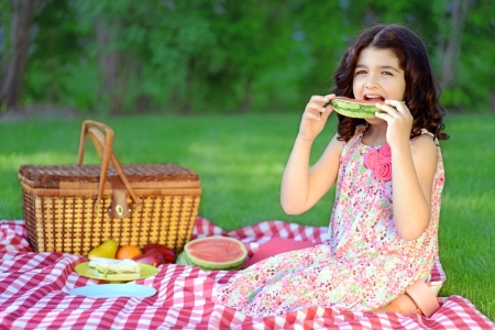 child with slice watermelon at picnicの写真素材