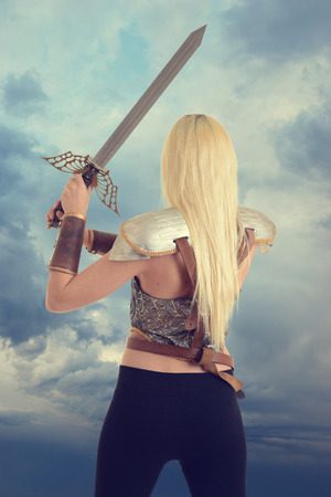 back of woman warrior holding a swordの写真素材