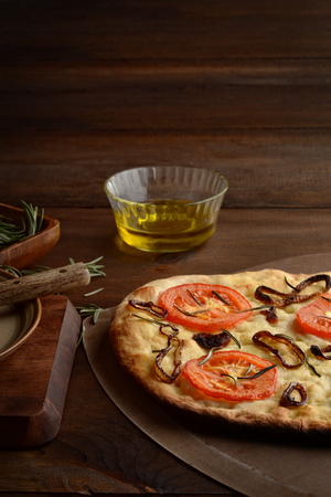 Closeup Focaccia With Caramelized Onions Tomatoes and Fresh Rosemaryの写真素材