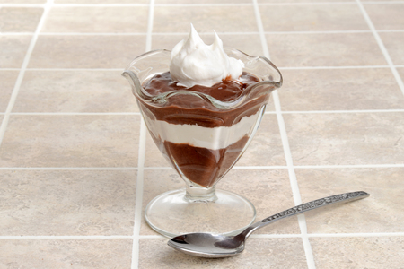 chocolate and whipped cream pudding with a spoonの写真素材