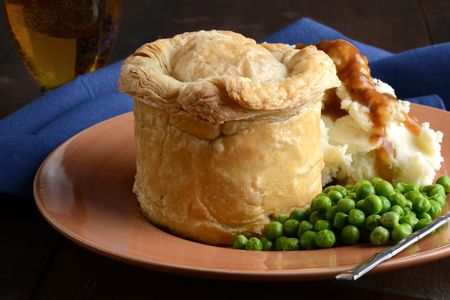 closeup pub meat pie with mashed potatoes and peasの写真素材