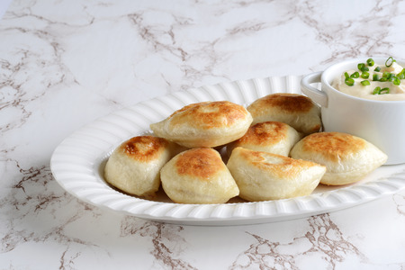 pierogies with sour cream and spring onionsの写真素材