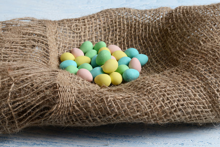candy easter eggs in burlap nestの写真素材