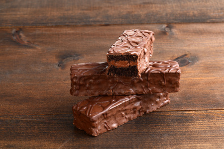 closeup sliced chocolate cream filled bar cake on woodの写真素材