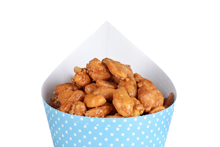 isolated closeup honey covered peanuts in a blue coneの写真素材