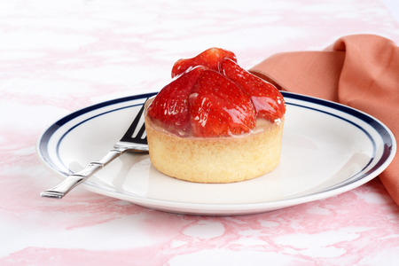 strawberry custard glazed tart on a plateの写真素材