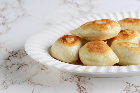 closeup crispy pierogies on a white platterの写真素材