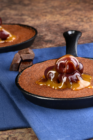 brownie with caramel sauce and cherriesの写真素材